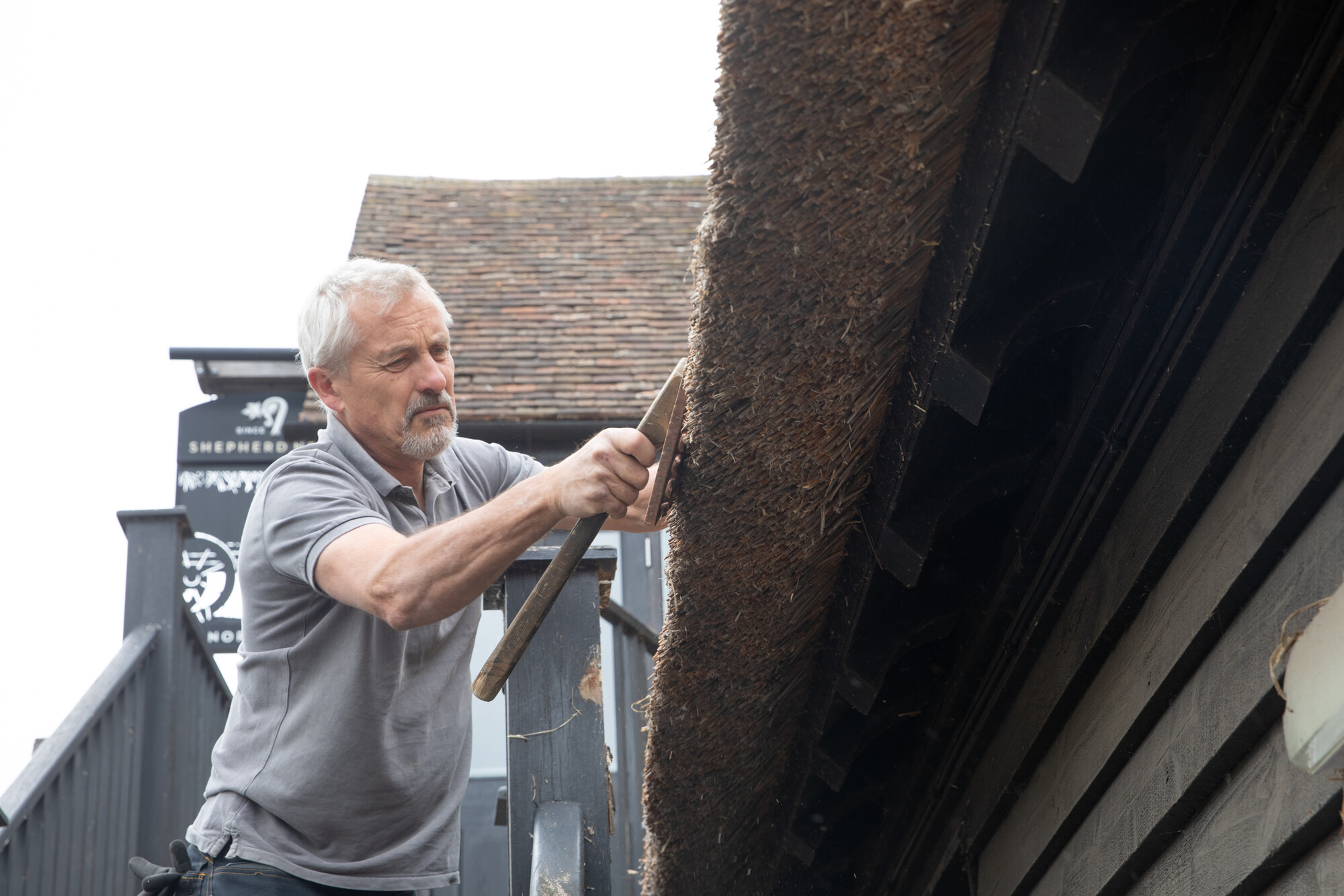 Glen Charter makes the finishing touches to the thatch of the Manor Farm Barn, Southfleet